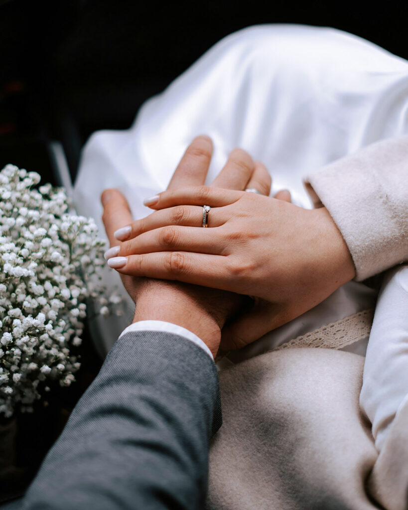 Braut und Bräutigam halten Hände in der Mercedes Limousine – Hochzeitsservice Wien